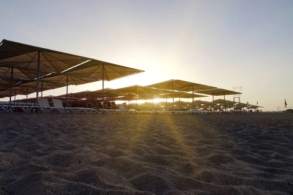 Leżaki i parasole na plaży. Przemysł turystyczny. — Zdjęcie stockowe