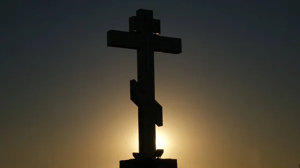 Le symbole de l'Eglise chrétienne et catholique : une silhouette de croix contre le coucher du soleil — Photo