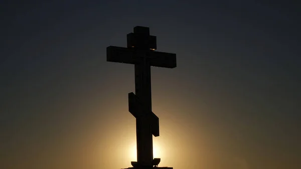 Il simbolo della Chiesa cristiana e cattolica: una sagoma di croce contro il tramonto — Foto Stock