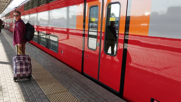열차의 출발을 기다리는 역에서 짐가지고 남자 여행자. 여행 남자의 개념 . — 스톡 사진