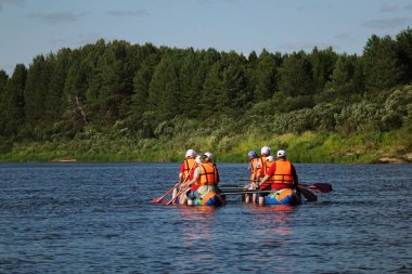 Şişme katamaran, açık hava etkinlikleri sessiz bir nehirde yüzen turist bir grup