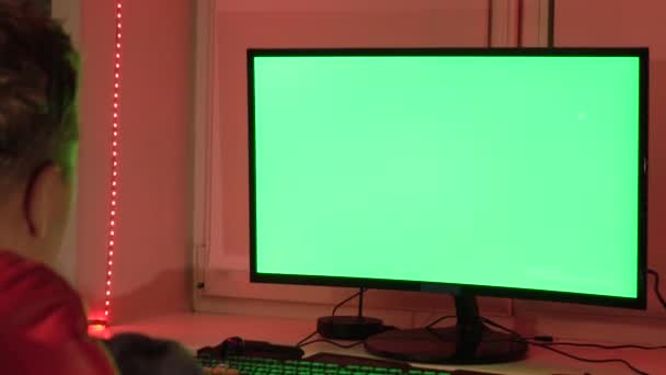 그의 홈 오피스, 녹색 컴퓨터 화면 앞에 한 남자가 있다. 가정에서 직장. — 비디오