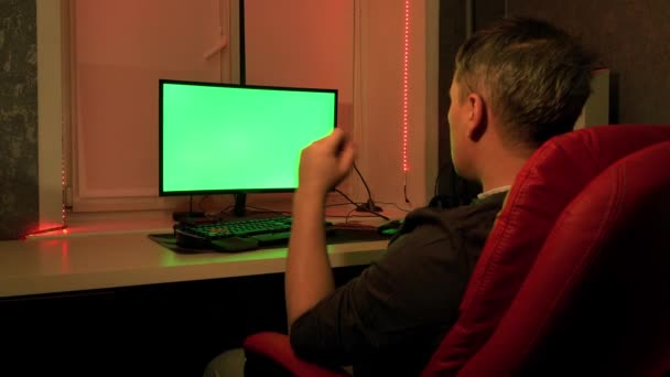 A man in his home office, in front of a green computer screen. Work at home. — Stock Video