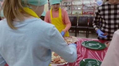 Rusya. Vologda-Aralık 2018: çocuklar pizza hazırlamak. Pizza pişirmek için çocuklar için Master sınıf. İtalyan mutfağı. Yavaş hareket.