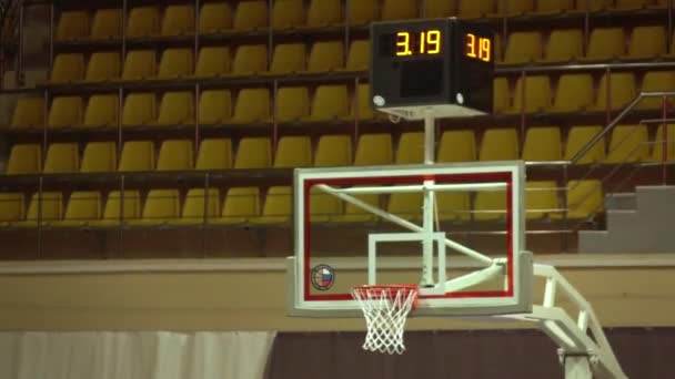 美しいスローバスケットボールフープスローモーション.ボールはバスケットに飛び込む。表彰台の背景。スポーツの概念. — ストック動画