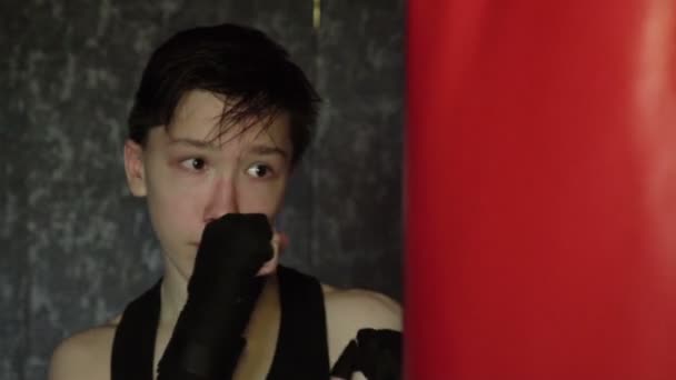 Un adolescente con una maglietta nera durante l'allenamento di boxe. Rallentatore — Video Stock