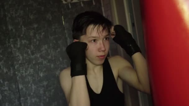 Uma adolescente com uma t-shirt preta no treino de boxe. Movimento lento — Vídeo de Stock