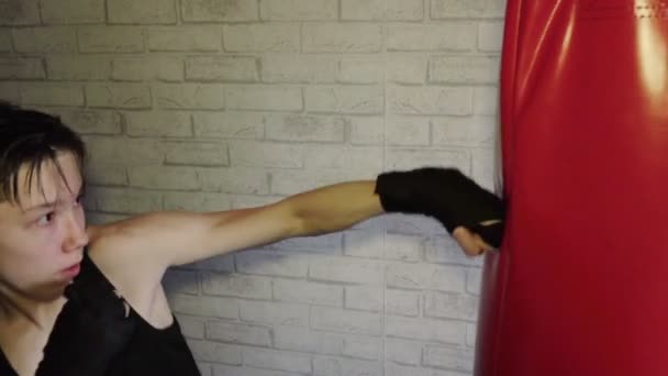 Un adolescente con una camiseta negra en entrenamiento de boxeo. Movimiento lento — Vídeos de Stock