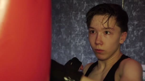 Un adolescente con una camiseta negra en entrenamiento de boxeo. Movimiento lento — Vídeo de stock