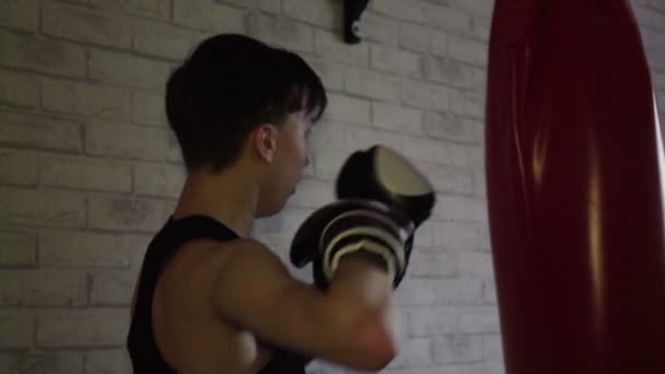 Un adolescent dans un t-shirt noir dans la formation de boxe. Mouvement lent — Video