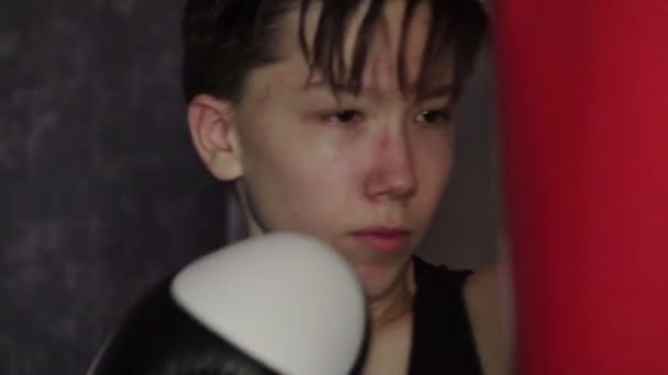 En tonåring i en svart t-shirt i boxning utbildning. Slow motion — Stockvideo