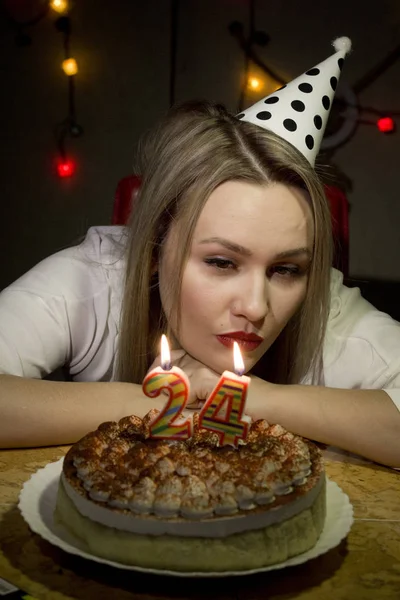 Lány születésnapi fúj ki a gyertyát a tortán a sötétben. — Stock Fotó