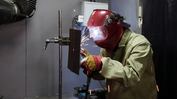 Schweißer in der Maske. das Metallprodukt wird mit einer Schweißmaschine geschweißt . — Stockfoto