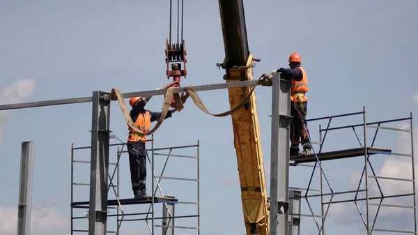 Metal dükkanının inşaatı. Şantiyede işçi ve ekipman.