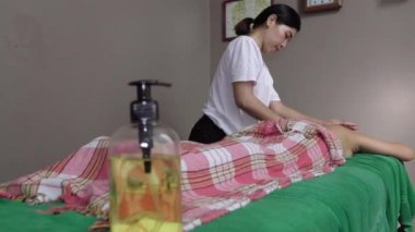 Bir kadın masör güzel bir kız için rahatlatıcı bir masaj yapar.