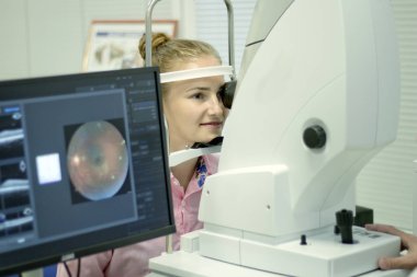 A young woman undergoes an ophthalmological examination, checking the health of the eyes and visual acuity. clipart