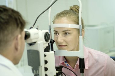 Genç bir kadın göz muayenesinden geçer, gözlerin sağlığını ve görme keskinliğini kontrol eder..