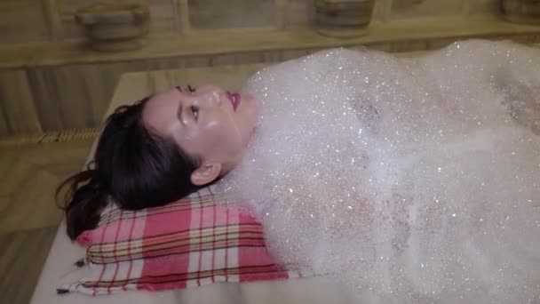 Mujer joven en bikini relajarse en Hammam. Asiática lleva a cabo un baño tradicional en un baño turco . — Vídeos de Stock