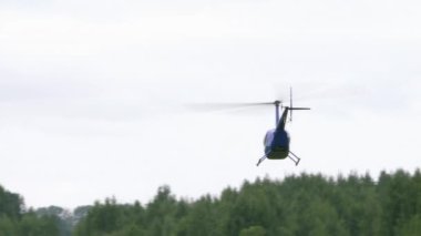 Özel helikopter gri gökyüzüne karşı havalanıyor