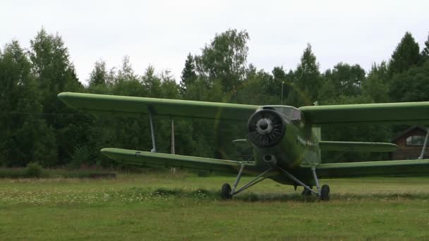 El avión an-2 en el aeródromo. Preparación para despegar en un campo verde . — Vídeo de stock