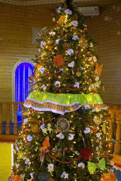 Ahşap bir evde Noel ağacı. Noel ağacı ışıklarla süslenmiş,