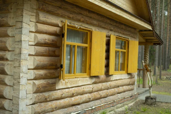 Drewniany dom z dziennikiem. Okno z okiennicami drewnianego domu — Zdjęcie stockowe