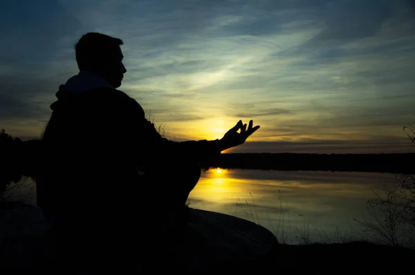 Silhueta de um homem meditante. Meditação como forma de relaxar . — Fotografia de Stock