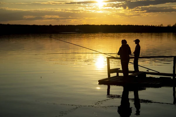 Zwei Silhouetten von Fischern auf dem See bei Sonnenuntergang . — Stockfoto