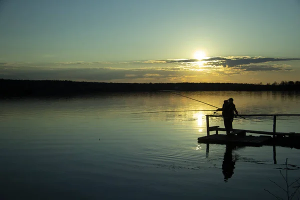 Dos siluetas de pescadores en el lago al atardecer  . —  Fotos de Stock
