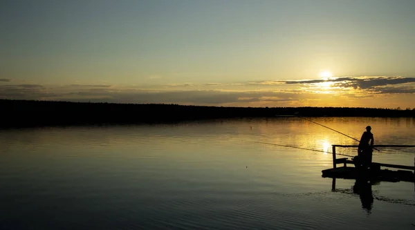 Dos siluetas de pescadores en el lago al atardecer  . —  Fotos de Stock