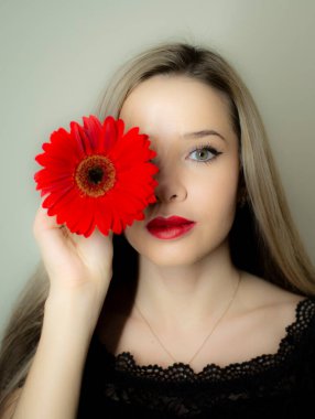 Kırmızı Gerbera çiçekli bir kızın portresi..