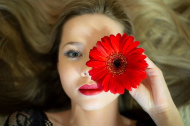 Kırmızı Gerbera çiçekli bir kızın portresi..