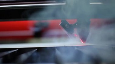 Bir 3D yazıcı lazer ışını tahta bir tahtadaki çizimi yakar.