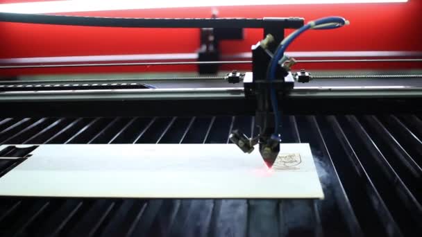Ein Laserstrahl aus dem 3D-Drucker brennt durch eine Zeichnung auf einem Holzbrett. — Stockvideo
