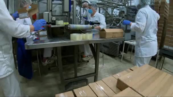 ヴォローダ。ロシア- 2020年7月:工場労働者が箱に油を詰めます。さらなる販売のための包装油のプロセス. — ストック動画