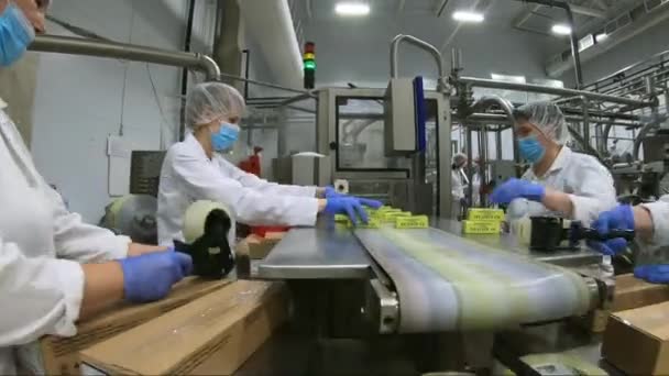 Vologda. Rusya-Temmuz 2020: fabrika işçileri bir kutuya petrol koyuyorlar. Daha fazla satış için ambalaj yağı süreci. — Stok video