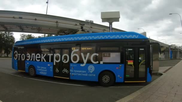 Moskwa. Rosja-sierpień 2020: Niebieski autobus elektryczny przy stacji ładowania, ładowanie ze pantografu. — Wideo stockowe