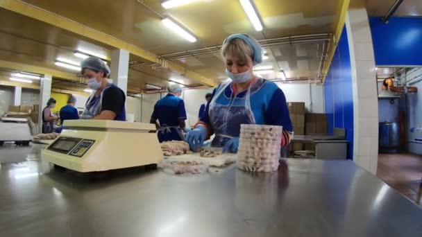 モスクワだ。ロシア- 2020年9月:缶詰の魚の生産のための店。女性は魚を切り取り、缶に詰め販売しています. — ストック動画