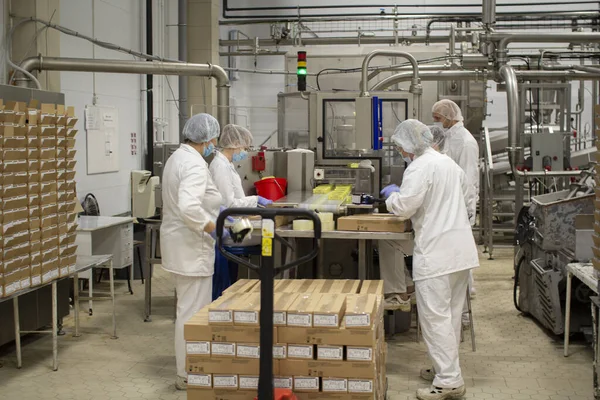 Wologda. Russland - Juli 2020: Fabrikarbeiter packen Öl in eine Schachtel. Der Prozess der Verpackung von Öl für den weiteren Verkauf. Stockfoto