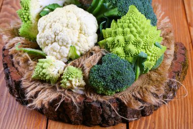 Different types of cabbage Broccoli, Romanesco on a wooden stump. clipart