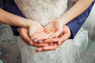 Gelinlerin elinde altın alyanslar.