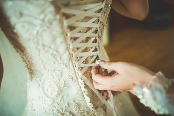 新婦付添人は結婚式の日のために花嫁を準備する 花嫁介添人は 式の前に花嫁のウェディングドレスを固定するのに役立ちます ドレスにニットコルセット 最高の結婚式の朝 結婚式のコンセプト — ストック写真