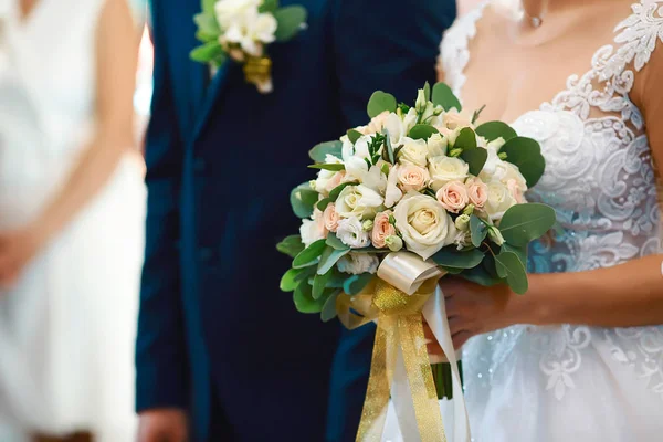 結婚式 白いドレスの女の子と 白いピンクの花と緑の美しい花束を持っているスーツの男は シルクリボンで飾られています — ストック写真