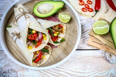 Tahta bir arka planda sığır eti, mantar, kıyma ve sebzeli dürüm. Biftek dürüm, Meksika yemeği. Sağlıklı yemek geçmişi. Meksika mutfağı.