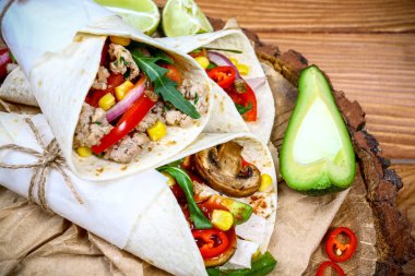 Sebzeli lezzetli burrito, baharatlı salsa ve ahşap kırsal arka plan manzaralı limon..