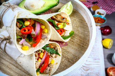 Burrito, Meksika ve Meksika yemekleri, kırmızı biberli un tortilla ahşap masada yakın çekim.