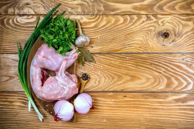 Eski bir köy masasında baharat ve sebzeli çiğ tavşan etinin fotokopisini çek. Yemek tarifi konsepti.