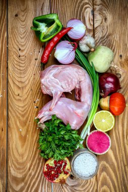 Ahşap masa arkasında sebzeli tavşan eti. Ev yapımı geleneksel mutfak tarifi. Düz görüş, yukarıdan. dikey resim.