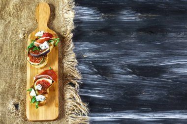 Jambonlu jambon ve peynirli bruschetta. İtalyan mezesi. Düz yatıyordu. Üst Manzara. Otantik yaşam tarzı görüntüsü. Mevsimlik hasat yerel ürün konsepti.