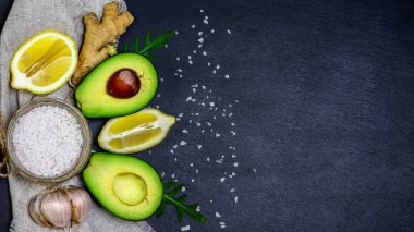 Yeşil sebze avokado, limon, zencefil, sarımsak, deniz tuzu, şist tahtasında roka salatası. Diyet ve kilo kaybı kavramı, kopyalama alanı, üst görünüm.